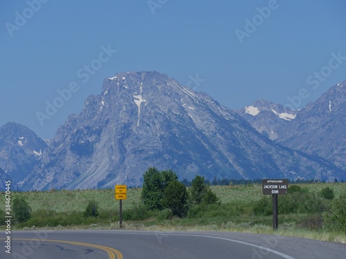 Roadside sign to Jackson Lake dam, with the Grand Teton mountain ranges in the background. © raksyBH