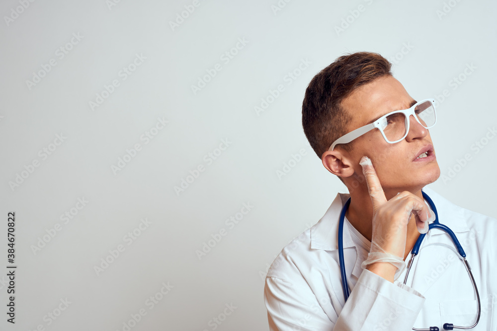 doctor in a medical gown with a stethoscope and glasses on a light background cropped view portrait doctor in a medical gown with a stethoscope and glasses on a light background cropped view portrait