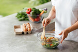 Human hands cooking vegetables salad in open kitchen