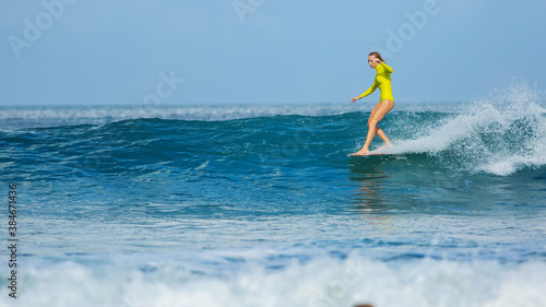 beautiful surfer girl rides a longboard
