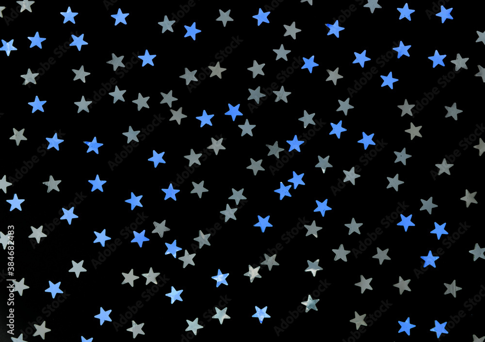 Blue and silver stars glitter on a black isolated background. Festive holiday backdrop. Blue and silver stars glitter on a black isolated background. Festive holiday backdrop.