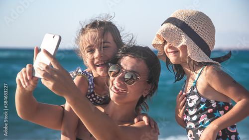 Canvas Print A mom with a child taking a selfie on the background of the sea