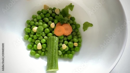 Creating an organic spontaneous creative spinach tree with french beans peas corn kernels and carrots dropped at random intervals