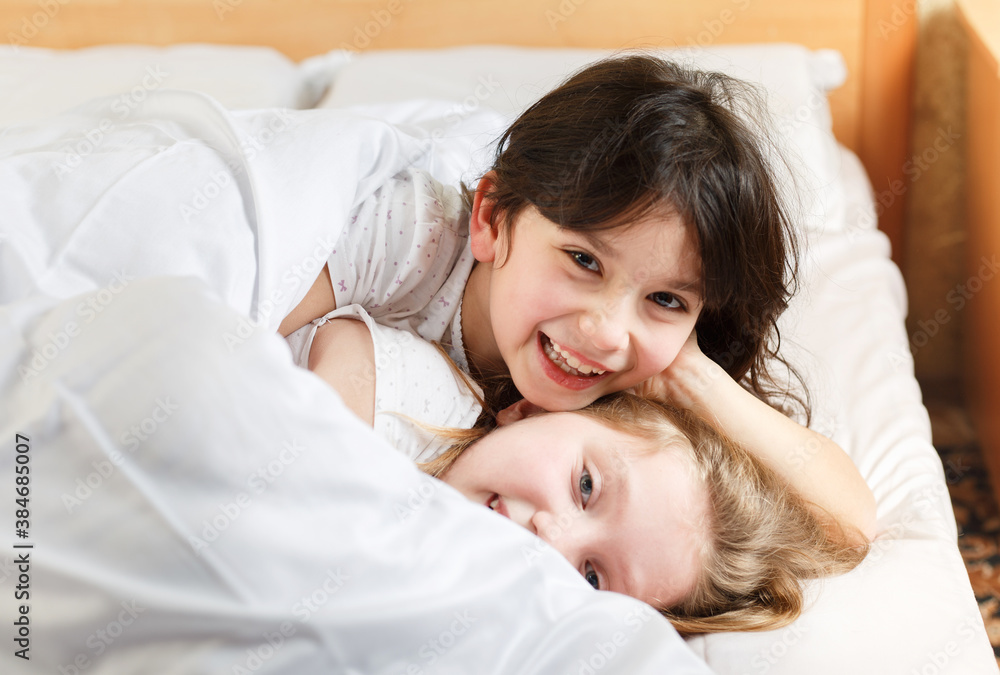 sisters playing in the bedroom on the bed sisters playing in the bedroom on the bed