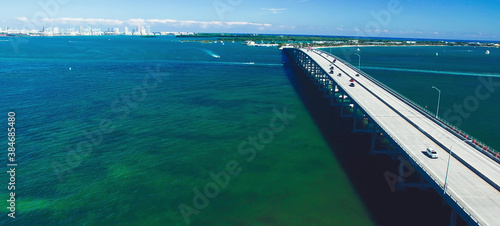 Traffic over Rickenbacker Causeway on a sunny day, aerial view from drone in slow motion.