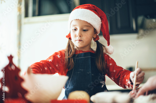 Caucasian girl is preparing food for christmas holidays wearing santa clothes and hat photo