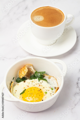 fried egg with herbs and black coffee for breakfast.