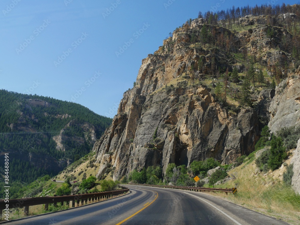 Incredible rock walls and geologic formations along a winding road cutting through the Bighorn Mountains in Wyoming.