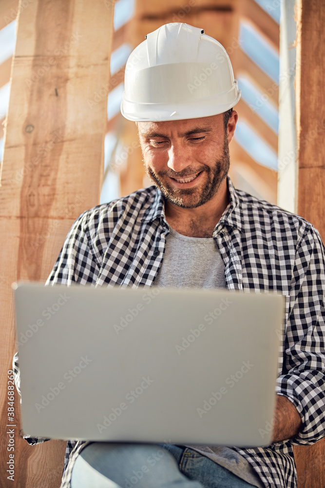 Joyous brunette field engineer working on his laptop Joyous brunette field engineer working on his laptop