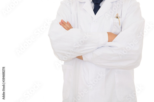 Doctor in white coat standing in front of white background holding arms