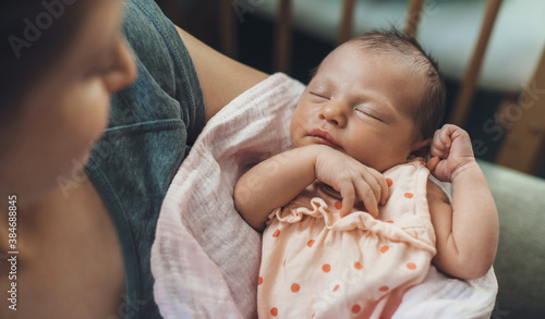 Konstfotografi Newborn baby sleeping in safety while mother is holding and smiling at her