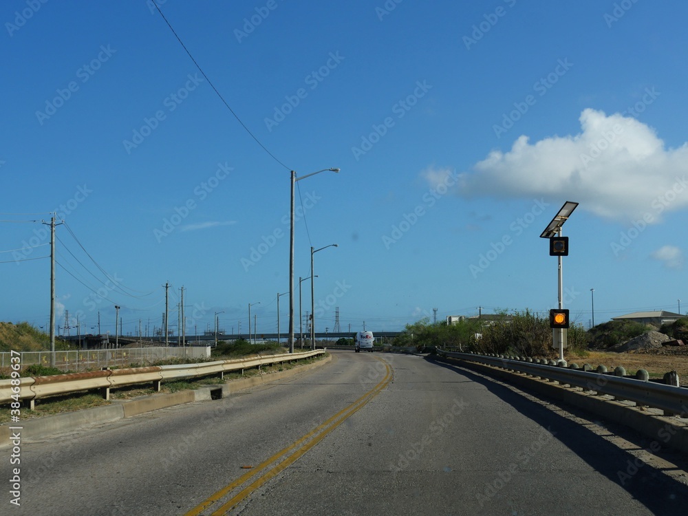 Galveston, Texas--June 2018: One of the roads in Galveston, with a FedEx truck travelling in the background.