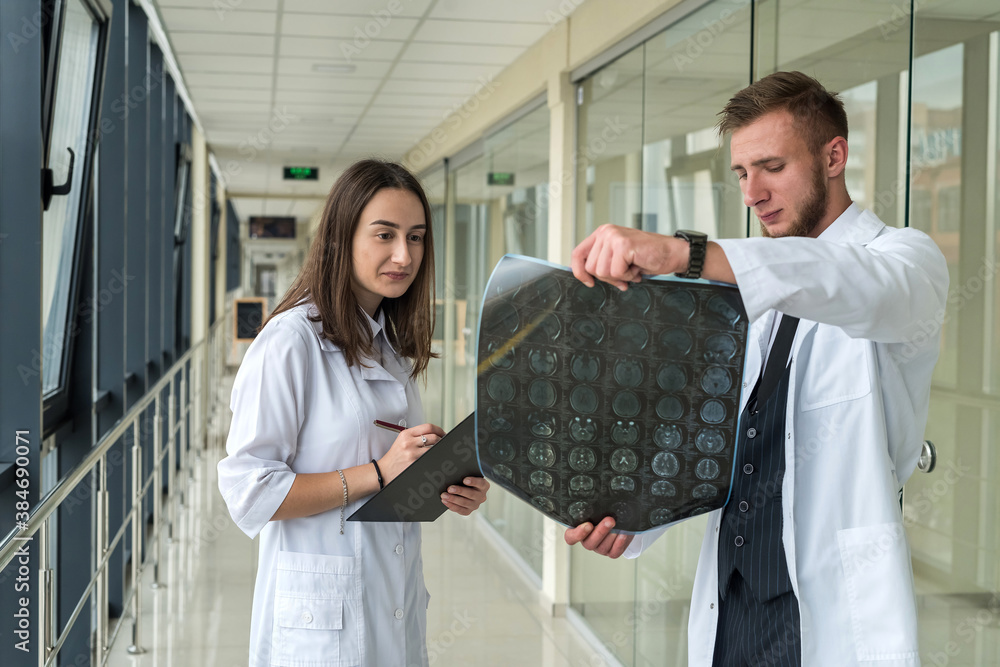 Obraz premium Two doctors discuss the results of X-ray MRI images of the patient?s brain in hospital
