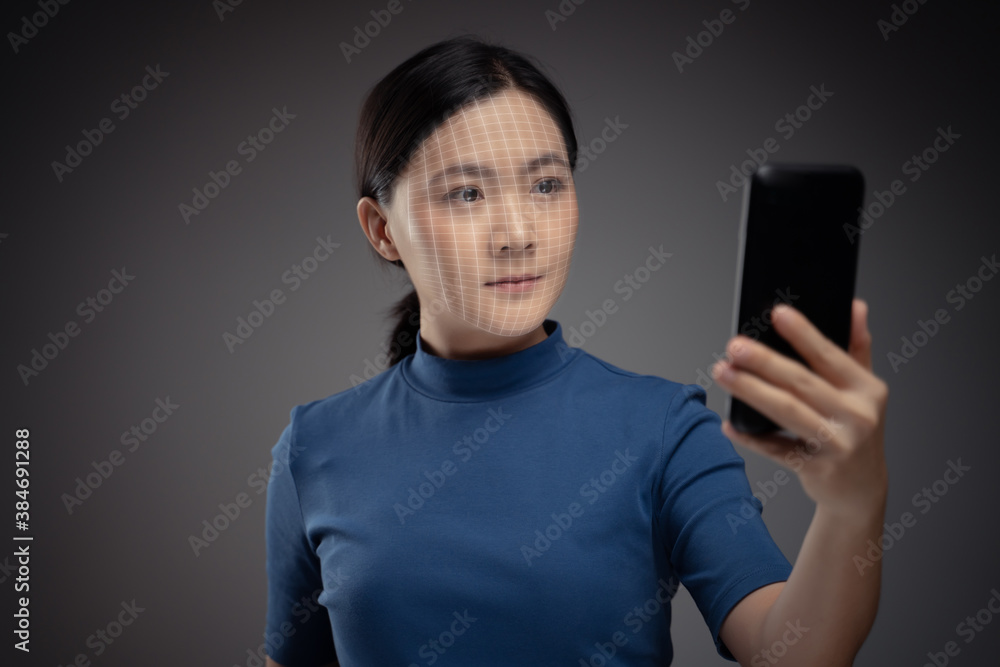 Asian woman scans face by smart phone using facial recognition system. Asian woman scans face by smart phone using facial recognition system.