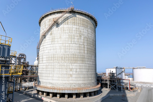 View of the double wall, cylindrical and vertical ammonia storage tank in the factory. Ammonia is used in numerous different industrial application requiring carbon or stainless steel storage vessels.
