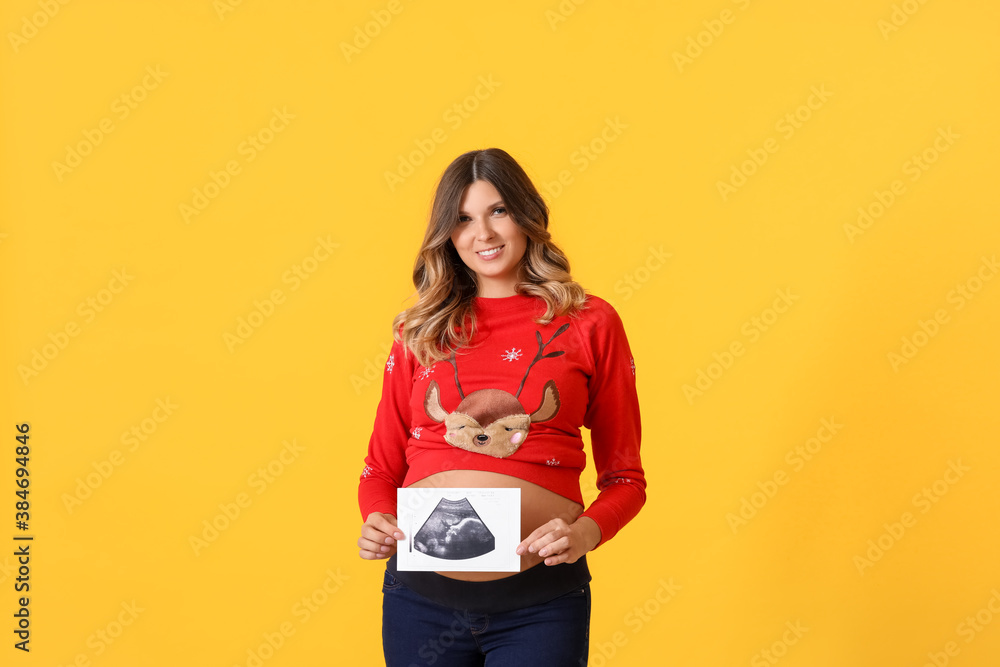 Beautiful pregnant woman with sonogram image on color background. Christmas celebration Beautiful pregnant woman with sonogram image on color background. Christmas celebration