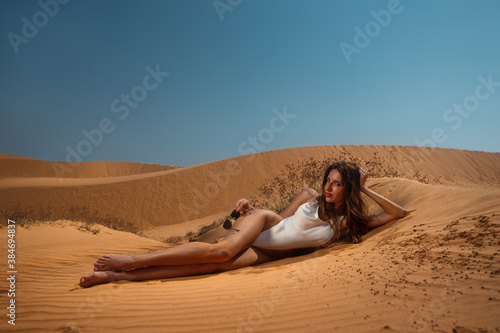 Fashion portrait of tanned woman on sand