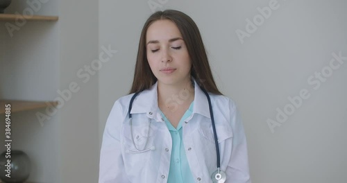 Looking at the camera listening woman doctor looks at the camera and listens to the patient. A video conference listener. Portrait of a doctor