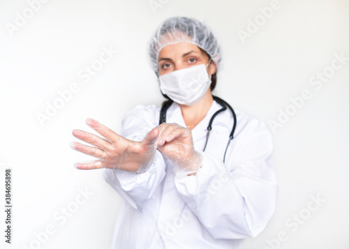 Protection against infections during the COVID epidemic. Dotkor woman in white coat, gloves and mask. Medicine and health concept. The main focus is on the hands. Copy space photo