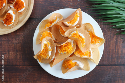 Thai Crispy pancake ( Thai dessert and snack called Kanom Buang) - Very famous authentic Thai snack at top view angle of the wood table photo