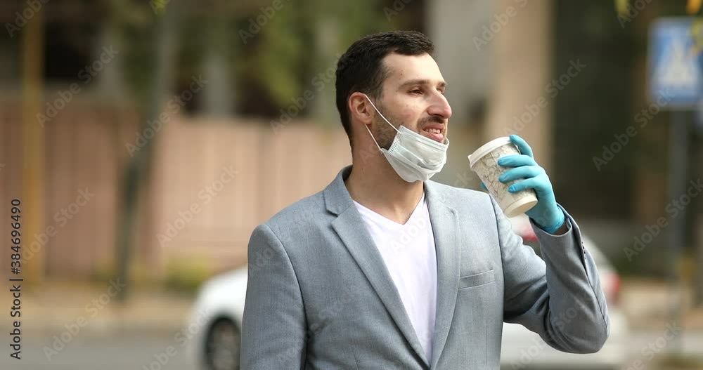 Man in protective medical mask drinking coffee to go. Man in protective medical mask drinking coffee to go.