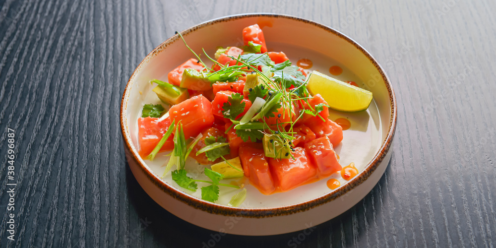 Watermelon salad with feta, fresh greenery and lime served in a unique shaped plate over black wooden table. Watermelon salad with feta, fresh greenery and lime served in a unique shaped plate over black wooden table.
