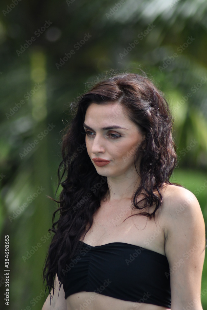 Face close up of young beautiful woman under a palm tree Face close up of young beautiful woman under a palm tree