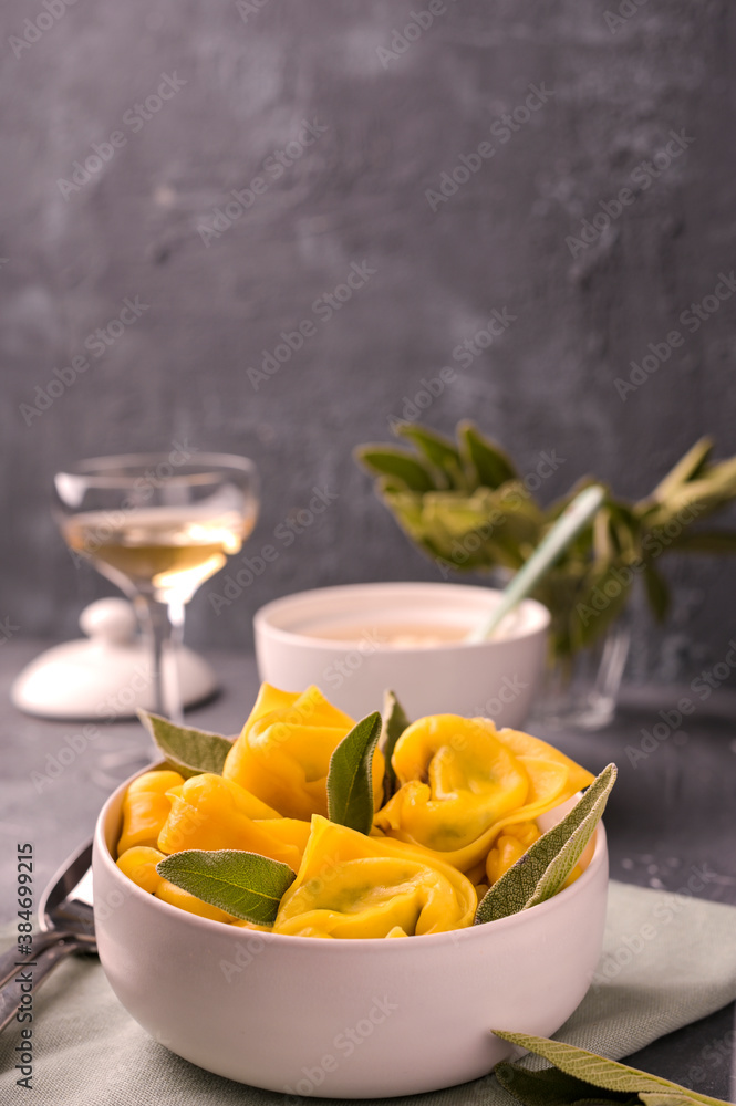 Tortellini with sage, ricotta and spinach. Italian pasta and white wine. Traditional Bologna cuisine, Emilia Romagna region. High quality photo. Copy space Tortellini with sage, ricotta and spinach. Italian pasta and white wine. Traditional Bologna cuisine, Emilia Romagna region. High quality photo. Copy space