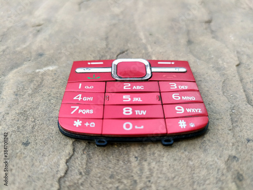 red color broken mobile keypad put on road