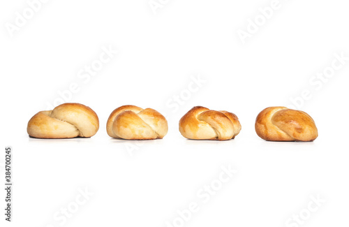 Four yeast bread buns arranged in a line. Multiple baked braided yeast knot roll with egg wash. Traditional Swiss butter bread called Zopf or Challah prepared for holiday meals. Isolated on white.