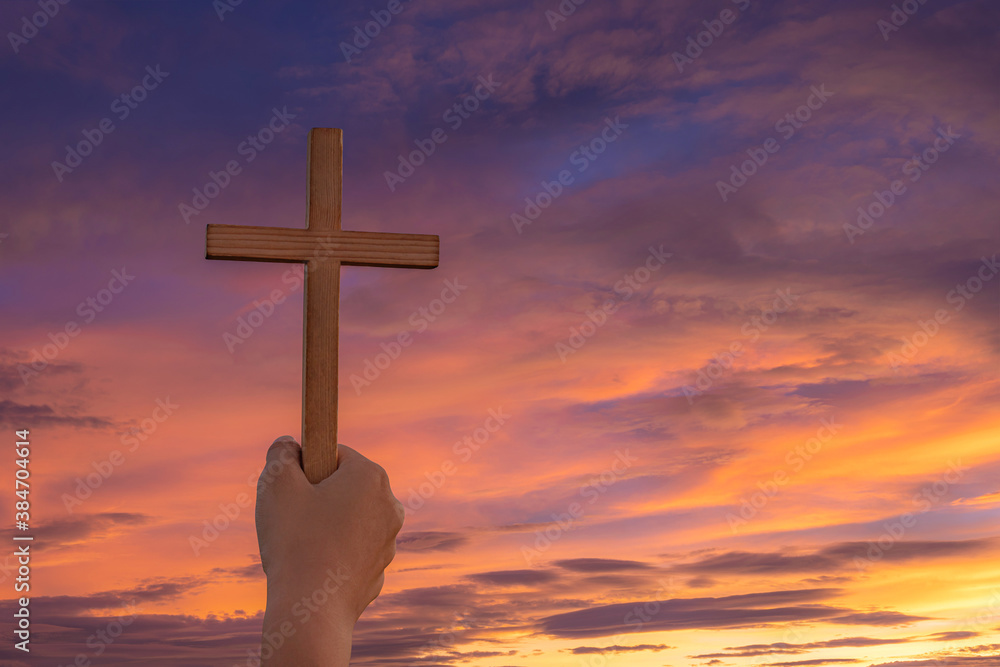 Christian, Christianity, Religion copy space background. Human praying and holding christian cross for worshipping God at sunset background.