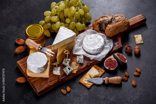 Beautiful delicious camembert cheese, parmesan, brie with grapes and figs