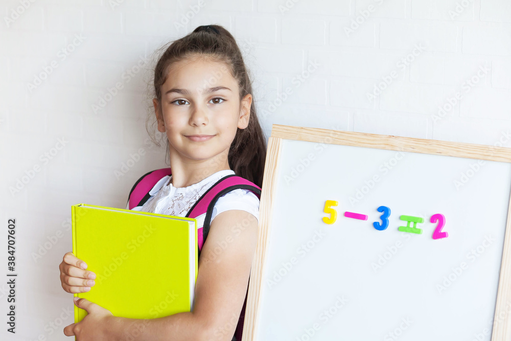 Back to school. Happy cute schoolgirl near the blackboard. Education and school concept. Back to school. Happy cute schoolgirl near the blackboard. Education and school concept.