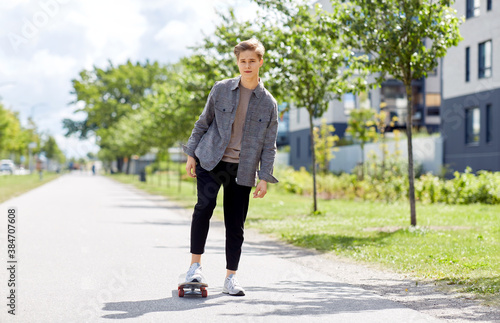 people and leisure concept - young man or teenage boy riding skateboard on city street © Syda Productions