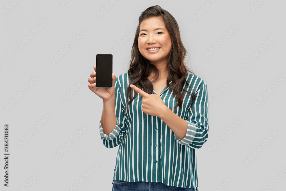 people and technology concept - happy asian young woman with smartphone over grey background people and technology concept - happy asian young woman with smartphone over grey background