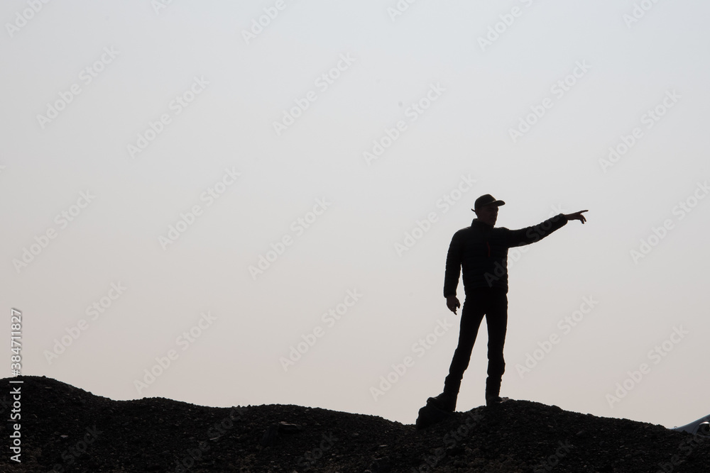 silhouette d'un homme marchant sur la crête d'une montagne