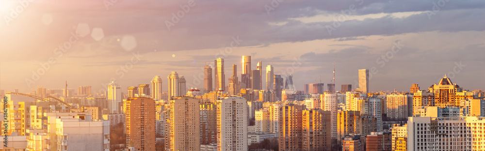 Fototapeta premium Panorama of Moscow from aerial view at sunset. Cityscape with Moscow City in the distance and modern multi-storey residential buildings in the foreground