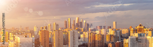 Panorama of Moscow from aerial view at sunset. Cityscape with Moscow City in the distance and modern multi-storey residential buildings in the foreground © hodim