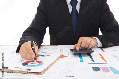 Financial practitioners in suits and ties are using calculators and comparing financial materials to analyze trends