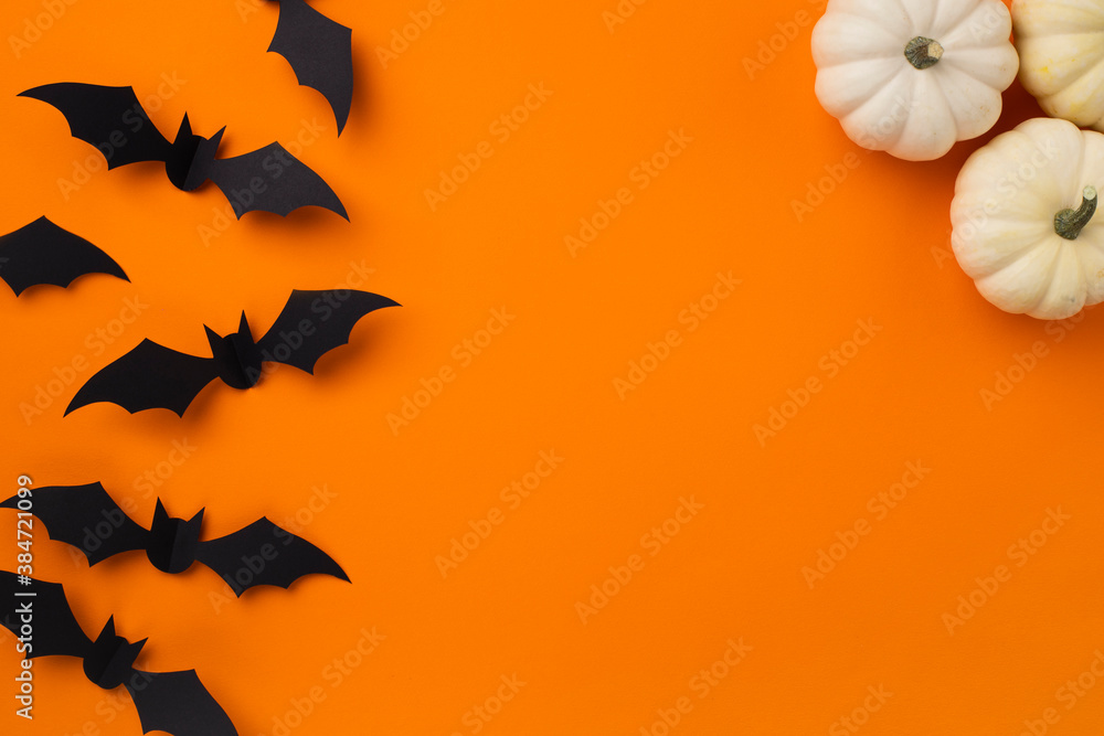 Happy halloween holiday concept. Halloween decorations, pumpkins and bats on orange background Happy halloween holiday concept. Halloween decorations, pumpkins and bats on orange background
