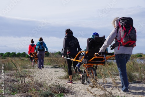 Randonnée solidaire avec handicap en joelette sorte de fauteuil roulant pour aider un handicapé à aller dans la nature