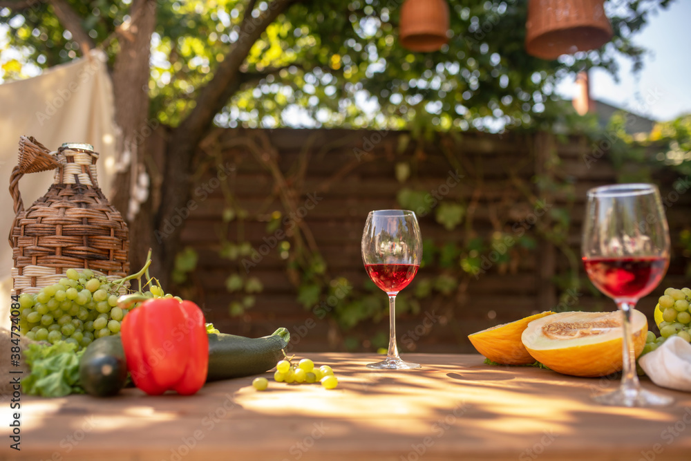 Two glasses of red wine on table with fruit and vegetables Two glasses of red wine on table with fruit and vegetables