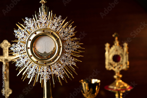 Catholic religion concept. Catholic symbols composition: The Cross, monstrance and golden chalice.