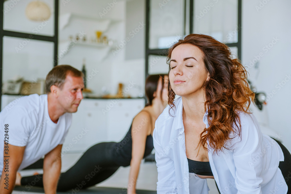 Fototapeta premium Yoga class of young people group indoor
