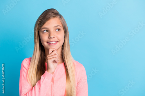Photo portrait of dreamy girl touching face chin with finger isolated on pastel blue colored background with copyspace
