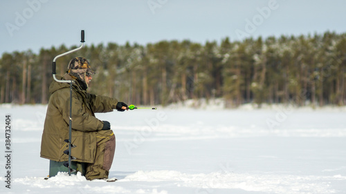 fisherman fishing on a winter lake. winter sport fishing
