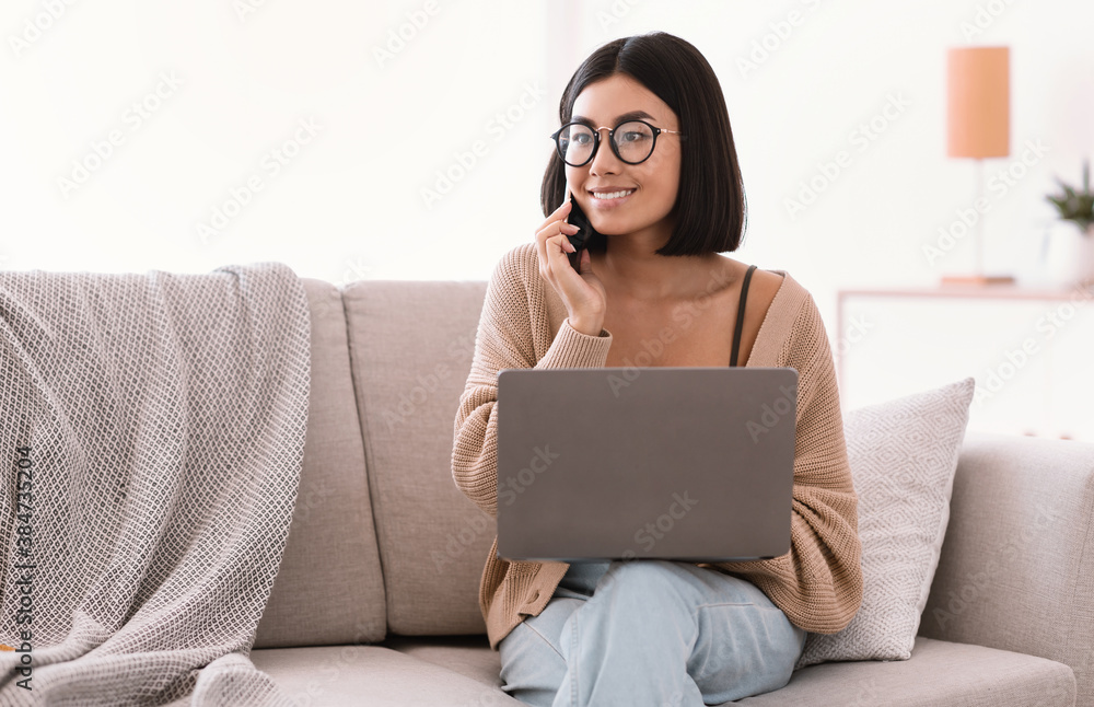 Portrait of smiling woman using pc talking on cellphone Portrait of smiling woman using pc talking on cellphone