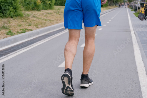 Handsome man jogging in the park. Sportsman runs exercising training outdoors.
