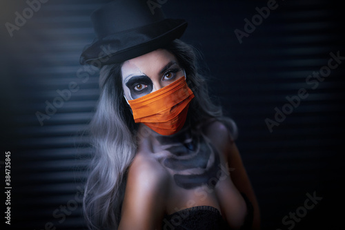 Fototapeta Naklejka Na Ścianę i Meble -  Spooky portrait of woman in halloween gotic makeup wearing protective mask