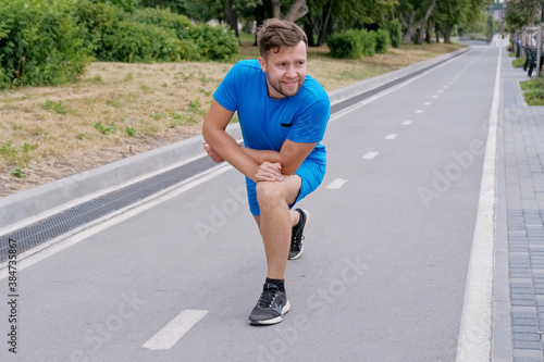 Handsome man jogging in the park. Sportsman runs exercising training outdoors.